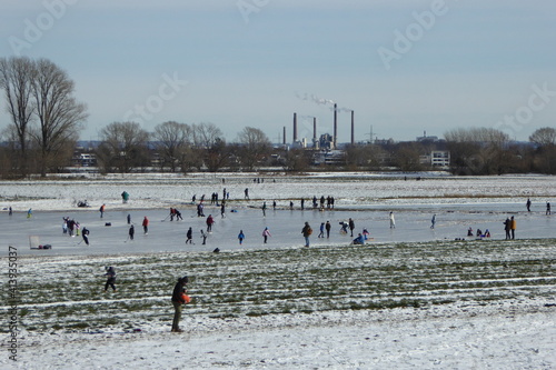 Auf den zugefrorenen Rheinwiesen im Uedesheimer Rheinbogen laufen viele Leute Schlittschuh. Nach leichtem Hochwasser und kalten Temperaturen locken schöne glatte Eisflächen viele Besucher an. photo