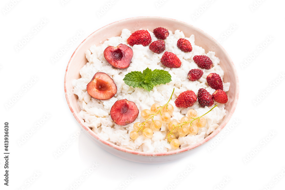 Rice flakes porridge with milk and strawberry in ceramic bowl isolated on white background. Side view. Rice flakes porridge with milk and strawberry in ceramic bowl isolated on white background. Side view.