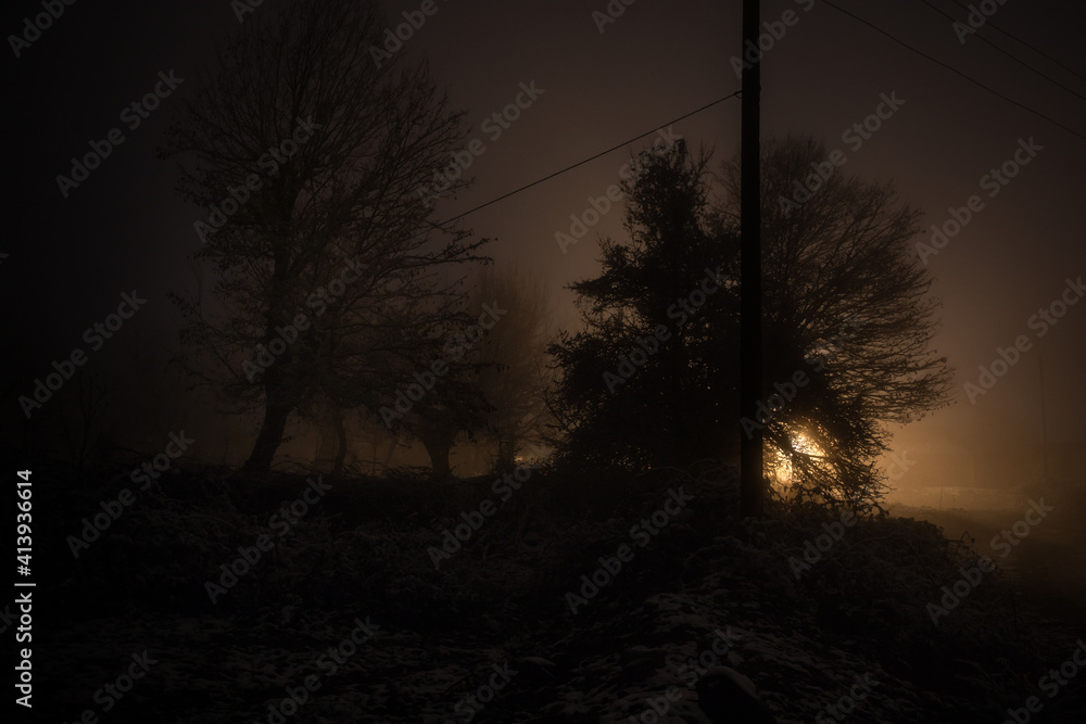 Night street country road with buildings and fences covered in fog lamp . Or Mysterious night in Azerbaijan mountain village Night street country road with buildings and fences covered in fog lamp . Or Mysterious night in Azerbaijan mountain village