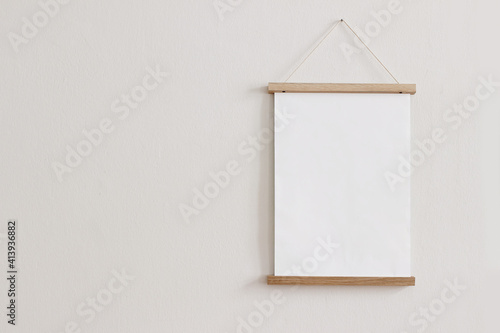 Fotografie Blank wooden picture frame hanging on beige wall