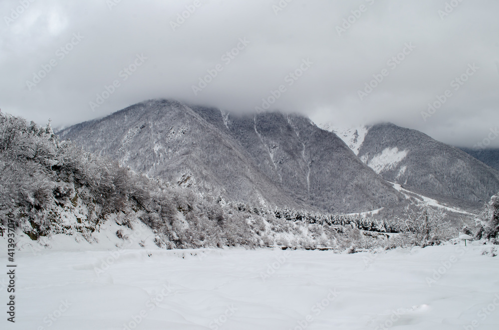 Winter trees in mountains covered with fresh snow. Beautiful landscape with branches of trees covered in snow. Mountain road in Caucasus. Azerbaijan Winter trees in mountains covered with fresh snow. Beautiful landscape with branches of trees covered in snow. Mountain road in Caucasus. Azerbaijan