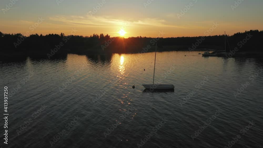 Aerial view around a anchored sailboat, sunny, summer evening - orbit, drone shot Aerial view around a anchored sailboat, sunny, summer evening - orbit, drone shot