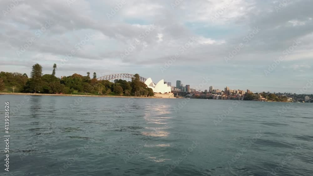 View Of The Iconic Sydney Opera House With Sydney Harbor Bridge Behind From The Waters Of Port Jackson In Australia. wide shot View Of The Iconic Sydney Opera House With Sydney Harbor Bridge Behind From The Waters Of Port Jackson In Australia. wide shot