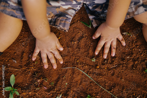 the boy's hand was playing on the dirty ground