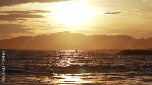 Man doing stand up paddle boarding in a nice sun bet