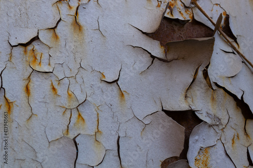 the paint is peeling off the rusting sheet of metal