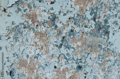 Close-up old plywood with cracked peeling blue paint, vintage background, outdoor weathered material. © Sergio 