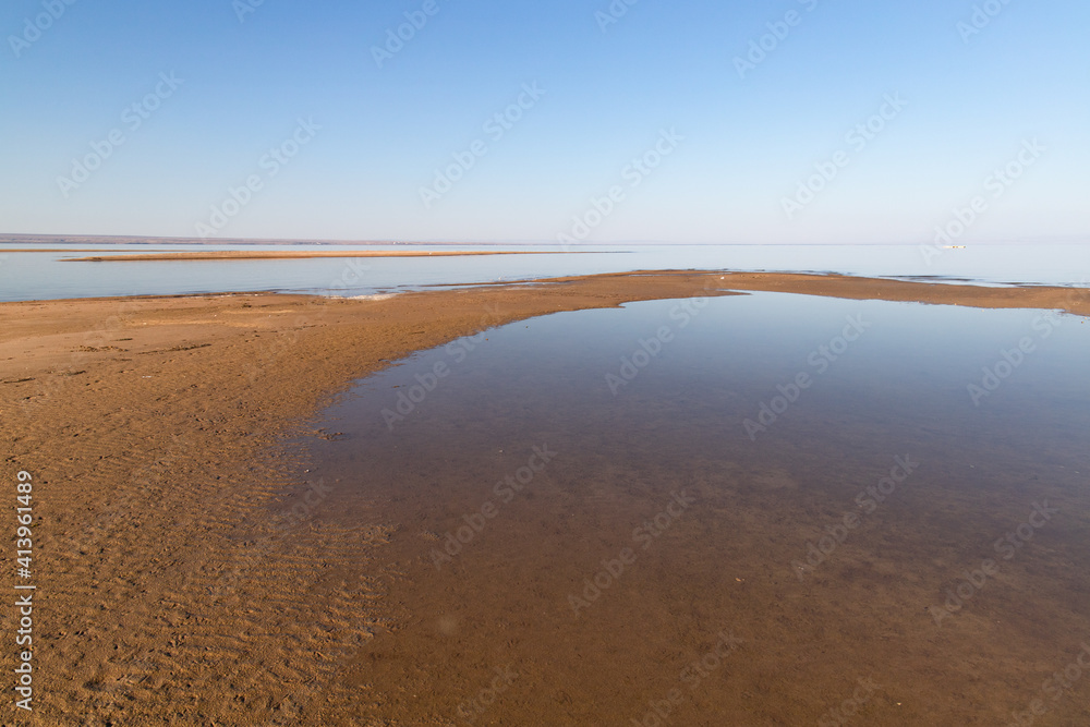 Low tide at sunset on the sea background.