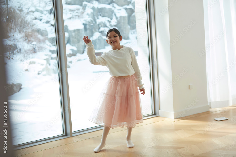 Happy little girl opening window curtains at home