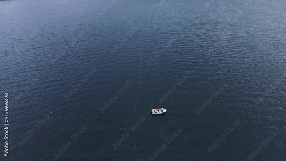 Tilt shot of a small fishing boat out in the middle of a beautiful Norwegian fjord Tilt shot of a small fishing boat out in the middle of a beautiful Norwegian fjord