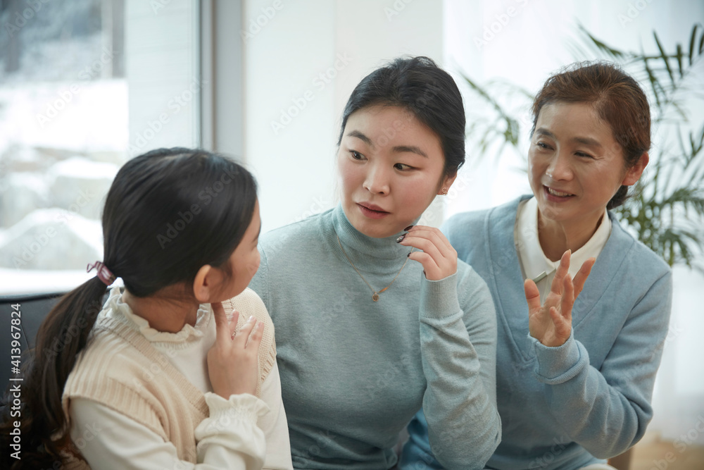 Little kid daughter and old mother while sitting on sofa at home Little kid daughter and old mother while sitting on sofa at home