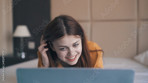 smiling woman lying in front of laptop internet leisure communication technology