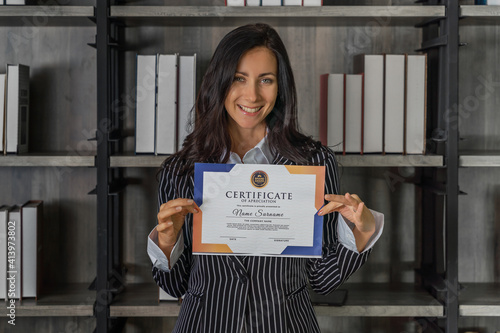 caucasian business woman posing with certificate of appreciation recieved from business performace competition photo