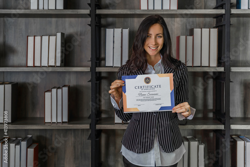 caucasian business woman posing with certificate of appreciation recieved from business performace competition