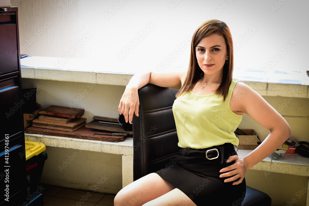 Mujer joven Guatemalteca en la oficina de una bodega de materiales. Secretaria sentada en una silla de oficina, con ropa formal, falda corta, blusa elegante y bonitas piernas. Mujer joven Guatemalteca en la oficina de una bodega de materiales. Secretaria sentada en una silla de oficina, con ropa formal, falda corta, blusa elegante y bonitas piernas.