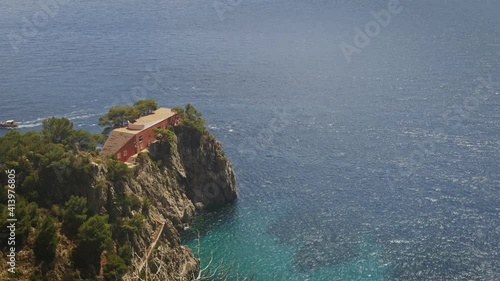 Tourists boat pass near villa Malaparte in Capri during a sunny day. Timelapse like tilt and shift effect. photo