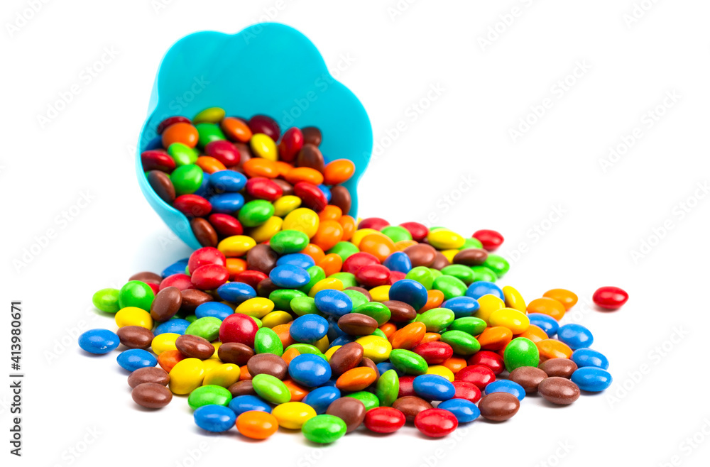 Rainbow Colored Candy Coated Chocolate Buttons in a Fun Blue Bowl Isolated on a White Background Rainbow Colored Candy Coated Chocolate Buttons in a Fun Blue Bowl Isolated on a White Background