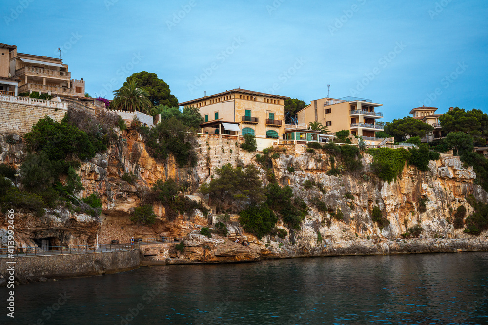 Houses on a cliff in the Porto Cristo bay on Mallorca island in Spain at evening