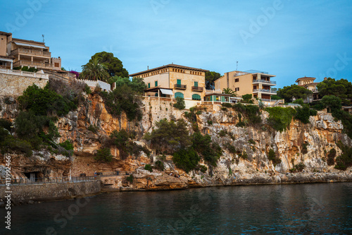Houses on a cliff in the Porto Cristo bay on Mallorca island in Spain at evening
