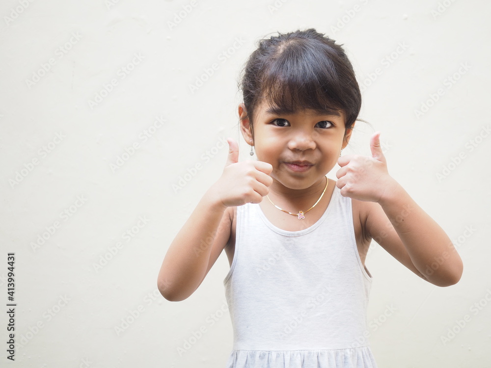 portrait of a little girl giving two thumbs up portrait of a little girl giving two thumbs up