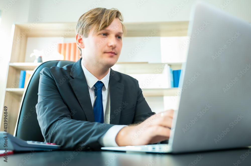Work at home, Video conference, Online meeting video call, Portrait of businessman looking at computer screen watching webinar and working on laptop in workplace Work at home, Video conference, Online meeting video call, Portrait of businessman looking at computer screen watching webinar and working on laptop in workplace