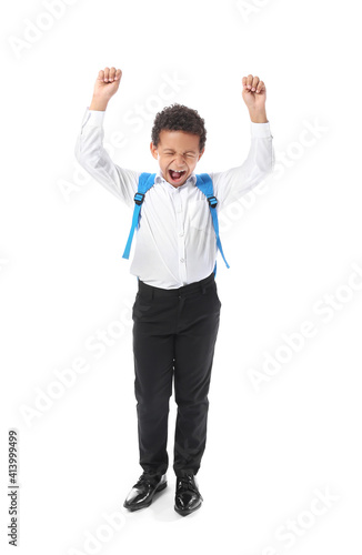 Happy little African-American schoolboy on white background