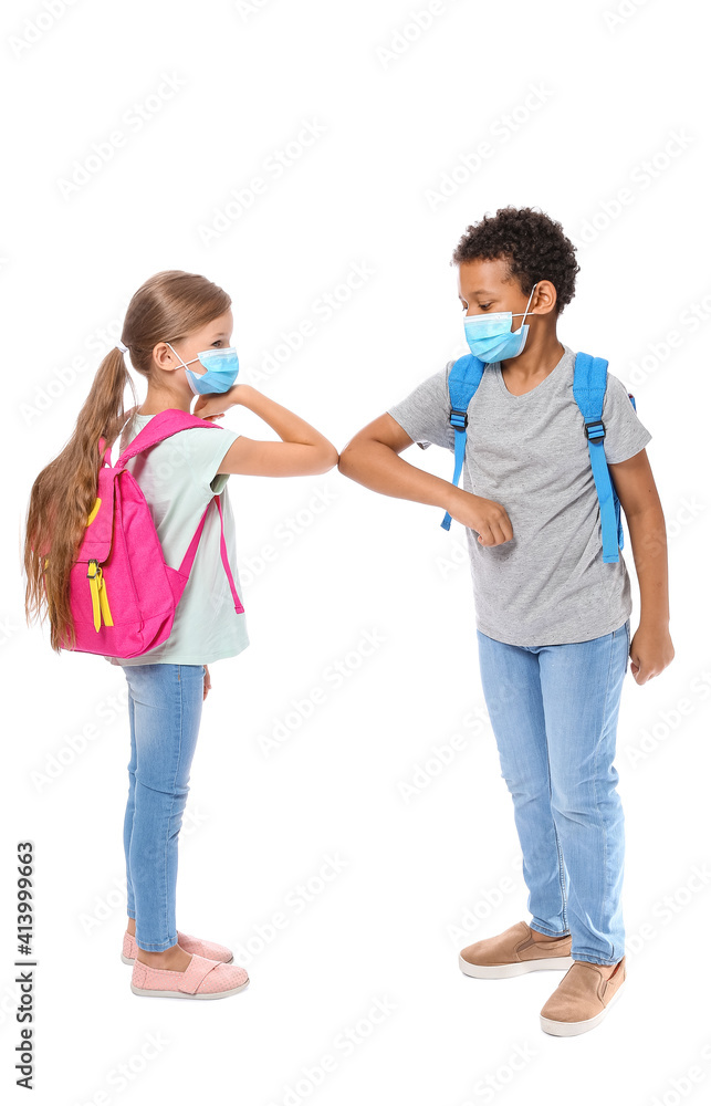 Little schoolchildren in medical masks greeting each other on white background. Coronavirus epidemic Little schoolchildren in medical masks greeting each other on white background. Coronavirus epidemic