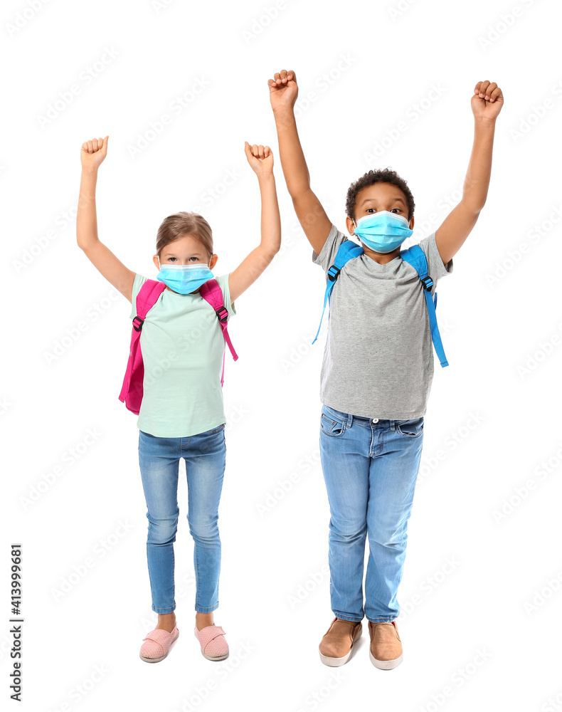 Happy little schoolchildren in medical masks on white background. Coronavirus epidemic Happy little schoolchildren in medical masks on white background. Coronavirus epidemic