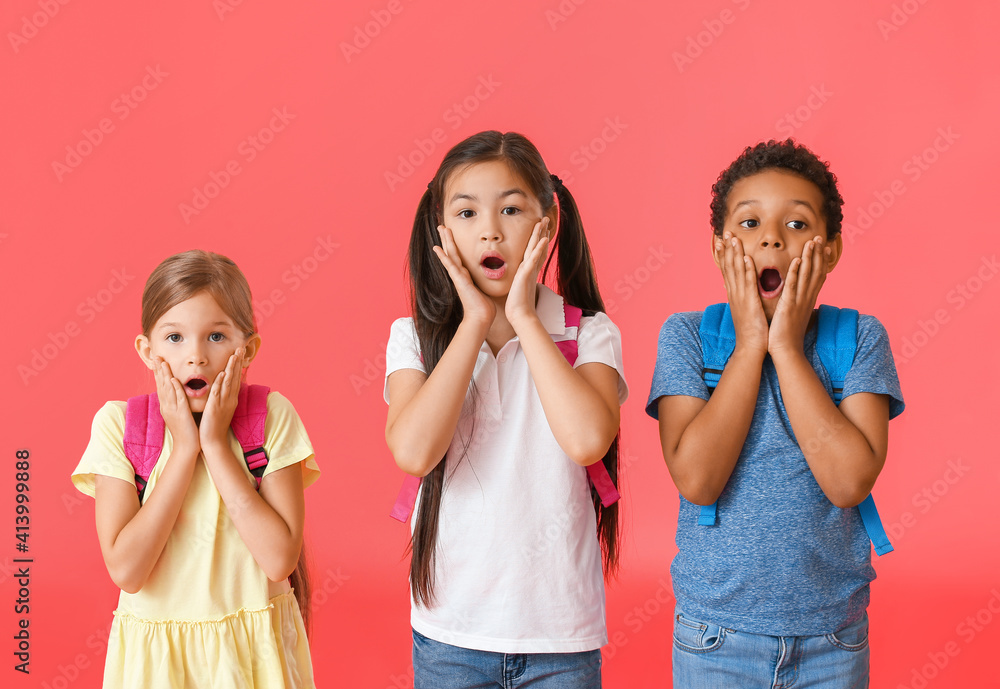 Surprised little schoolchildren on color background Surprised little schoolchildren on color background