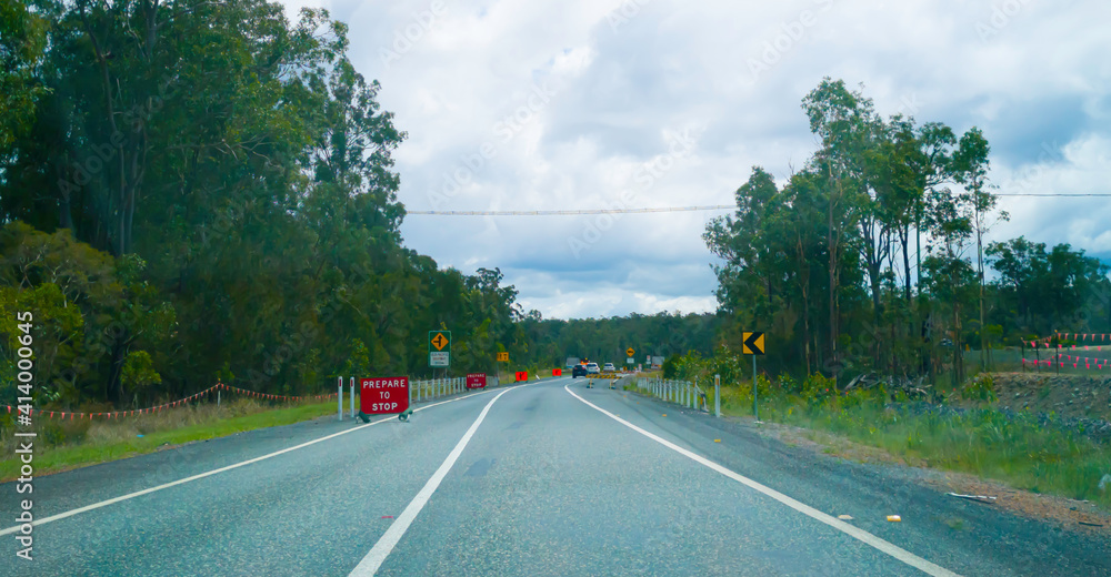 Road work sign on the Pacific Highway east coast Australia surrounded by forest.	