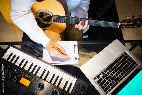 Fototapeta top view of male songwriter writing a song with laptop computer and keyboard on desk