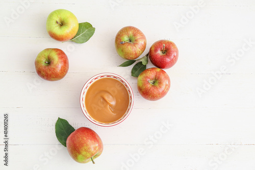 Bowl with sweet apple jam on light background