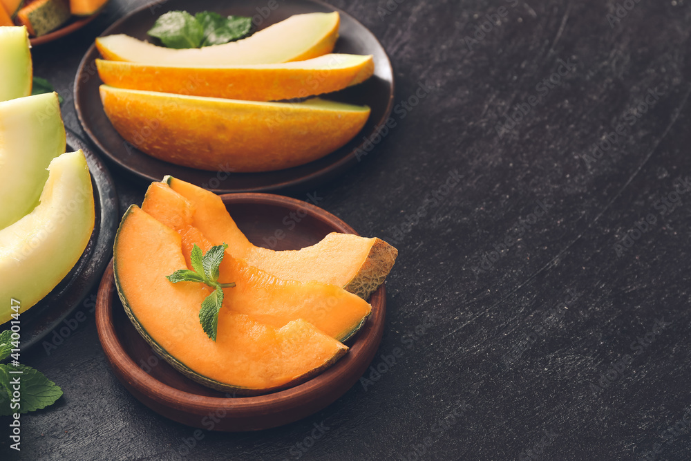 Plates with sweet cut melon on dark background Plates with sweet cut melon on dark background