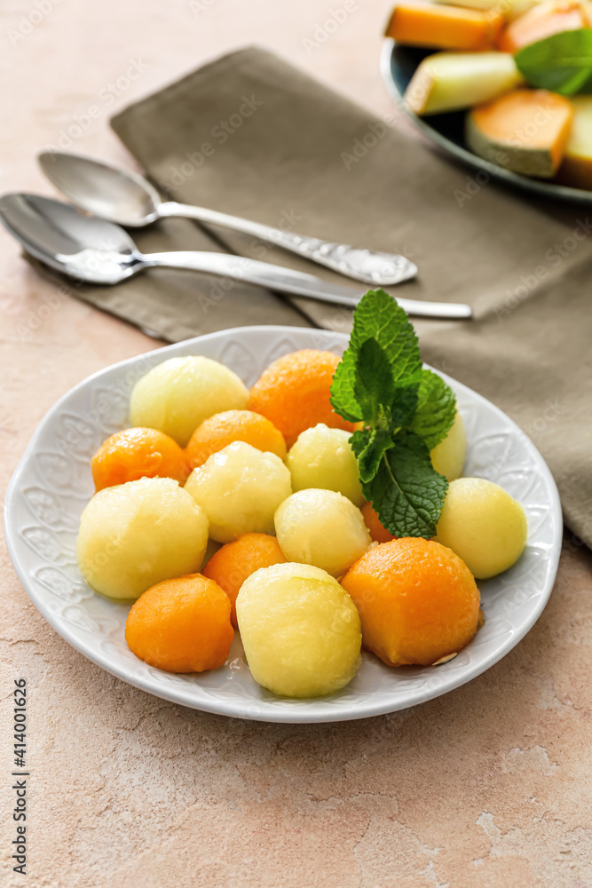 Plate with sweet melon balls on color background Plate with sweet melon balls on color background
