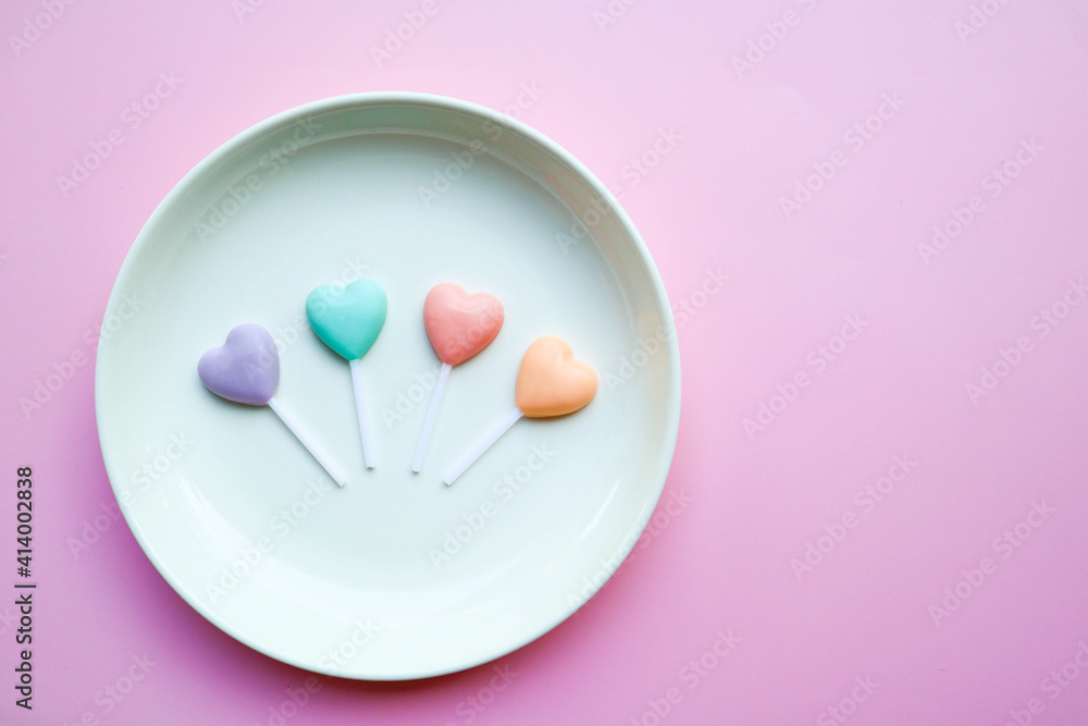 Heart shape chocolate in pastel color on the white plate of pink background with copy space - Love and cute concept Heart shape chocolate in pastel color on the white plate of pink background with copy space - Love and cute concept