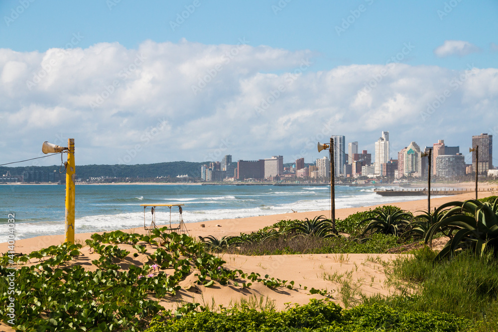 Dune Covered with Vegetation and Buildings in Background