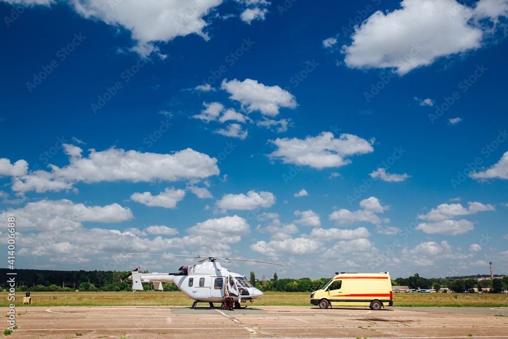 Fototapeta premium A helicopter and an ambulance are on the runway. Transport concept for medical personnel