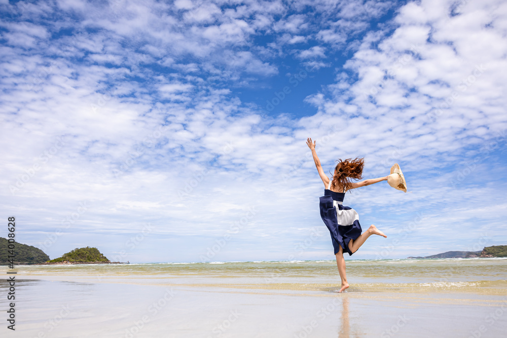 Woman barefoot jump in the water on summer along wave of sea water and sand on the beach. Woman barefoot jump in the water on summer along wave of sea water and sand on the beach.