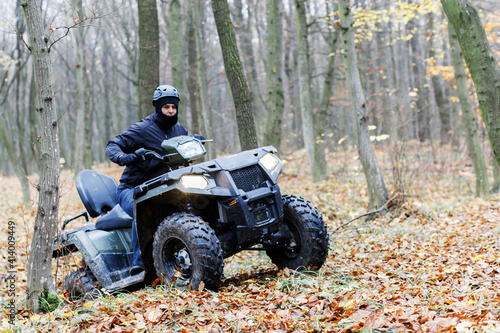 Travel without roads. ATV. A man rides through the forest on an all-terrain vehicle. Quad bike. In the woods. ATV trip to the forest