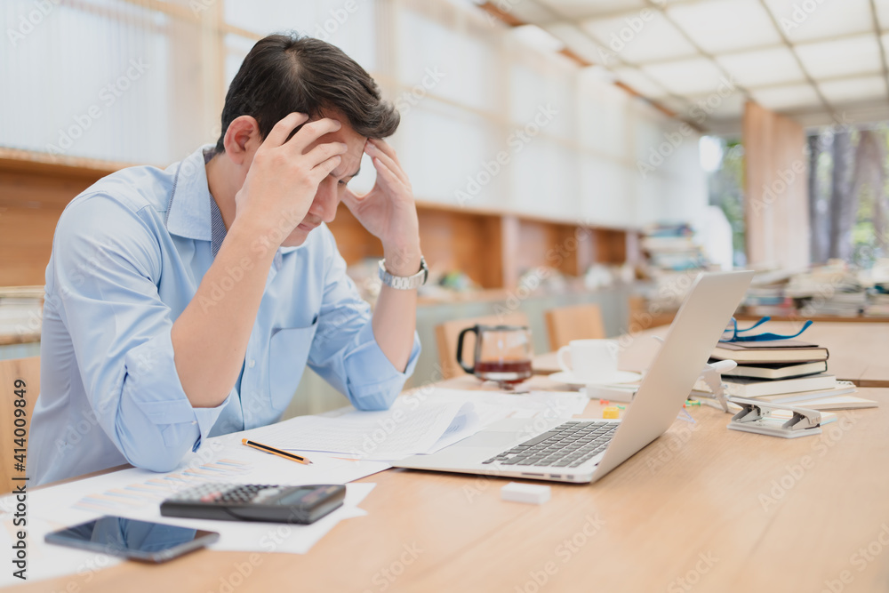 Tired businessman at workplace in office holding his headache or angry. Overworking, making mistake, stress, termination, fail, bad, sad tired or depression concept Tired businessman at workplace in office holding his headache or angry. Overworking, making mistake, stress, termination, fail, bad, sad tired or depression concept