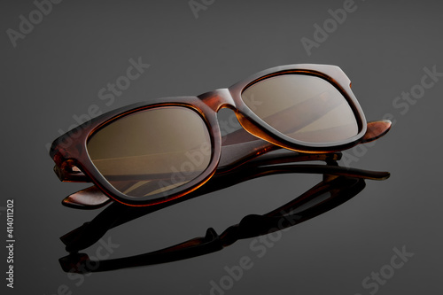 Fashion-framed sunglasses on black mirrored background