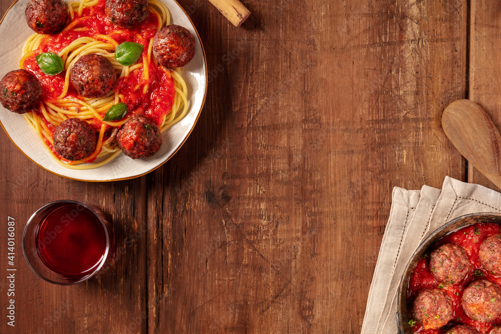 Meatballs banner design. Meatbalss with pasta and tomato sauce, overhead flat lay shot on a dark rustic wooden background with copy space