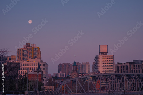 A full moon is setting on the Bund in the early morning