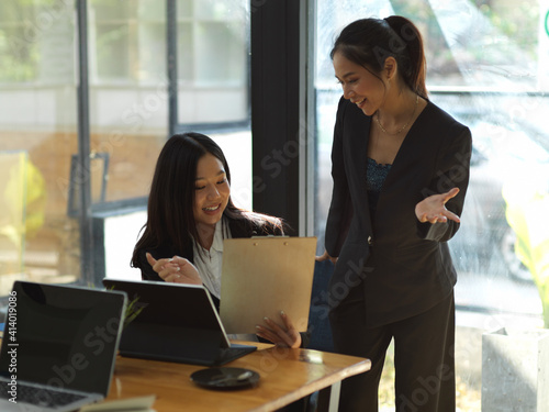 Two businesswomen consulting on their project while working in office room