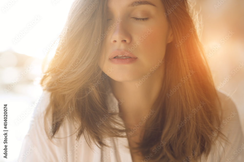 Fototapeta premium Beautiful woman. Young girl with rays of sunset bill. Portrait. High quality photo.