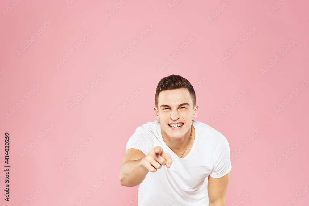 Cheerful handsome man in white t-shirt emotions pink isolated background Cheerful handsome man in white t-shirt emotions pink isolated background