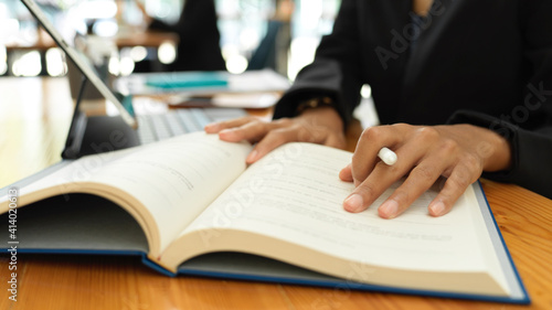 Female student reading textbook to prepare for her coming exam