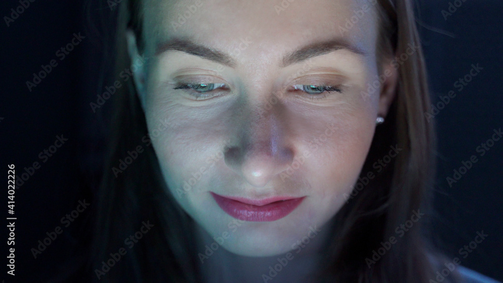 Close up portrait woman using tablet computer browsing online watching movie at night Close up portrait woman using tablet computer browsing online watching movie at night