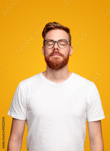 Redhead man breathing calmly with closed eyes