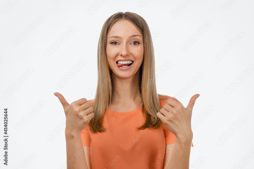 Portrait of attractive blond girl in casual clothes showing thumbs up. Studio shot, white background Portrait of attractive blond girl in casual clothes showing thumbs up. Studio shot, white background